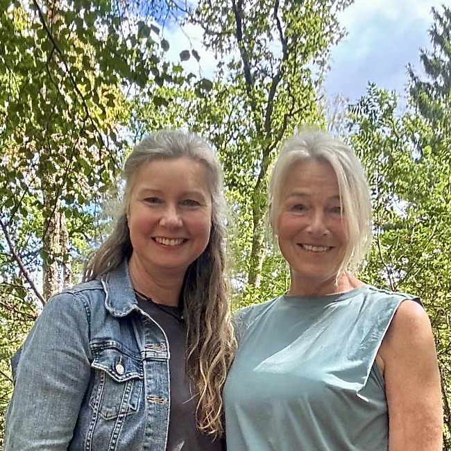 Daniëlle en Renée, begeleiders van Rouw in Beeld, samen lachend in een groene, bosrijke omgeving